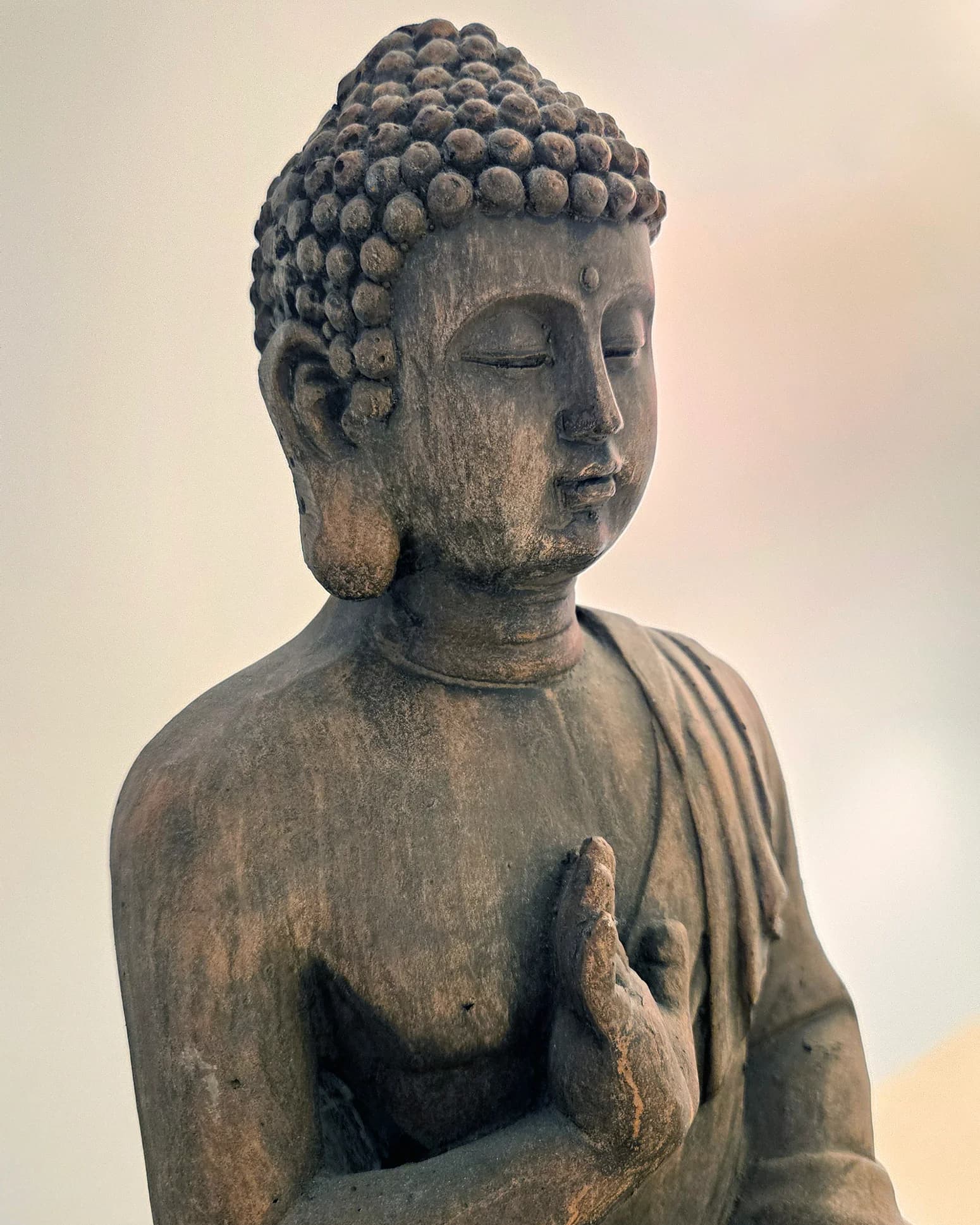 Statuette de Bouddha en pierre, les yeux fermés, symbole de détente